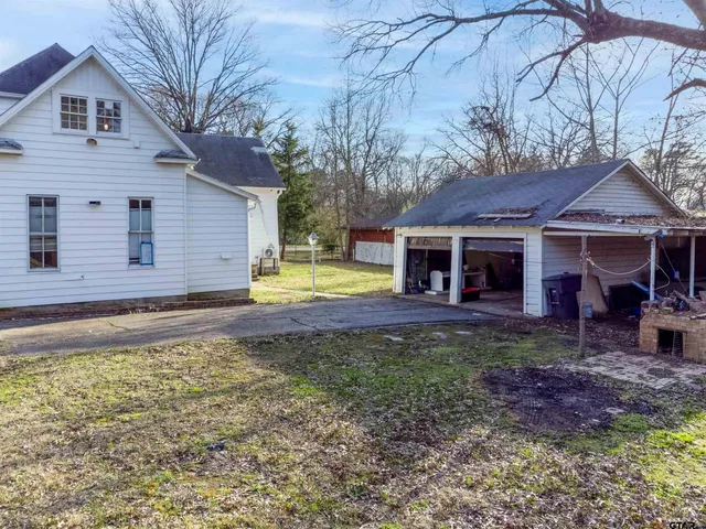 a view of a house with backyard and trees