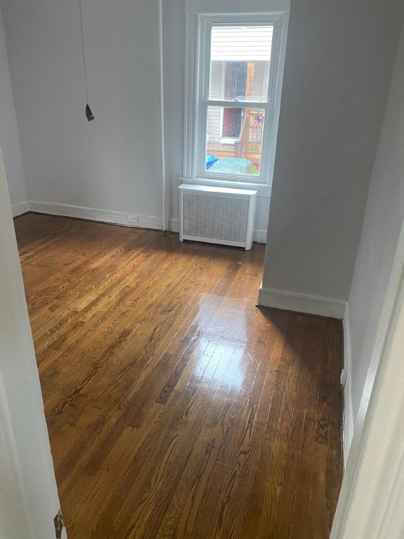 91-93 Grover Street Springfield, MA 01104 - Photo 3 of 12 an empty room with wooden floor and windows