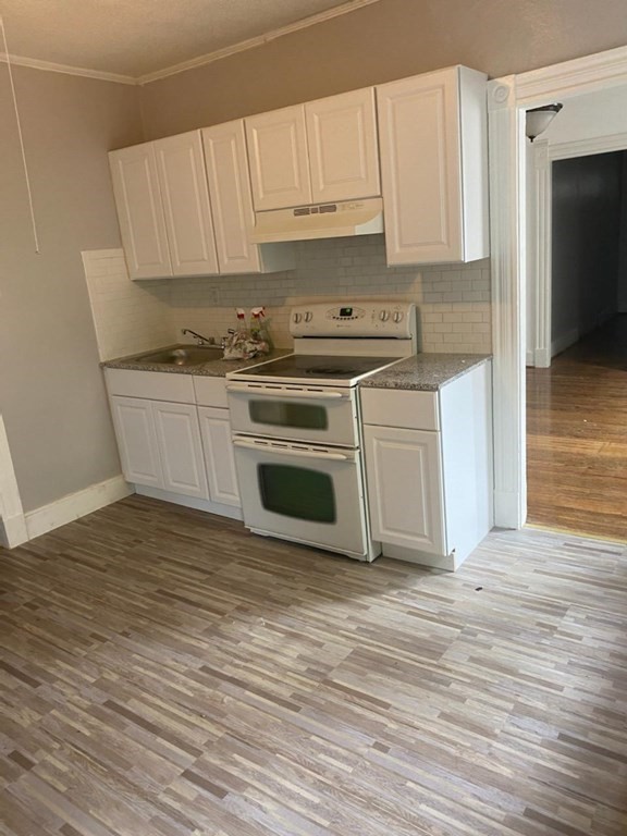 91-93 Grover Street Springfield, MA 01104 - Photo 5 of 12 a kitchen with granite countertop a stove a sink and a refrigerator