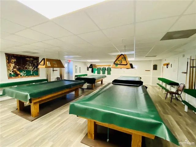 a room with pool table wooden floor and windows