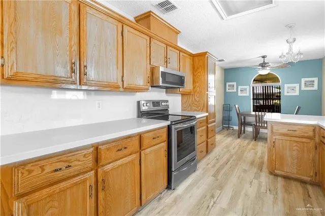 a kitchen with stainless steel appliances granite countertop a stove a sink and a refrigerator