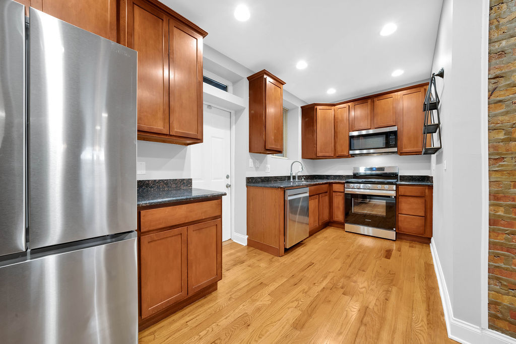 2256 West Arthur Avenue, Unit 2 Chicago, IL 60645 - Photo 5 of 18 a kitchen with stainless steel appliances granite countertop a refrigerator a stove a sink and a microwave