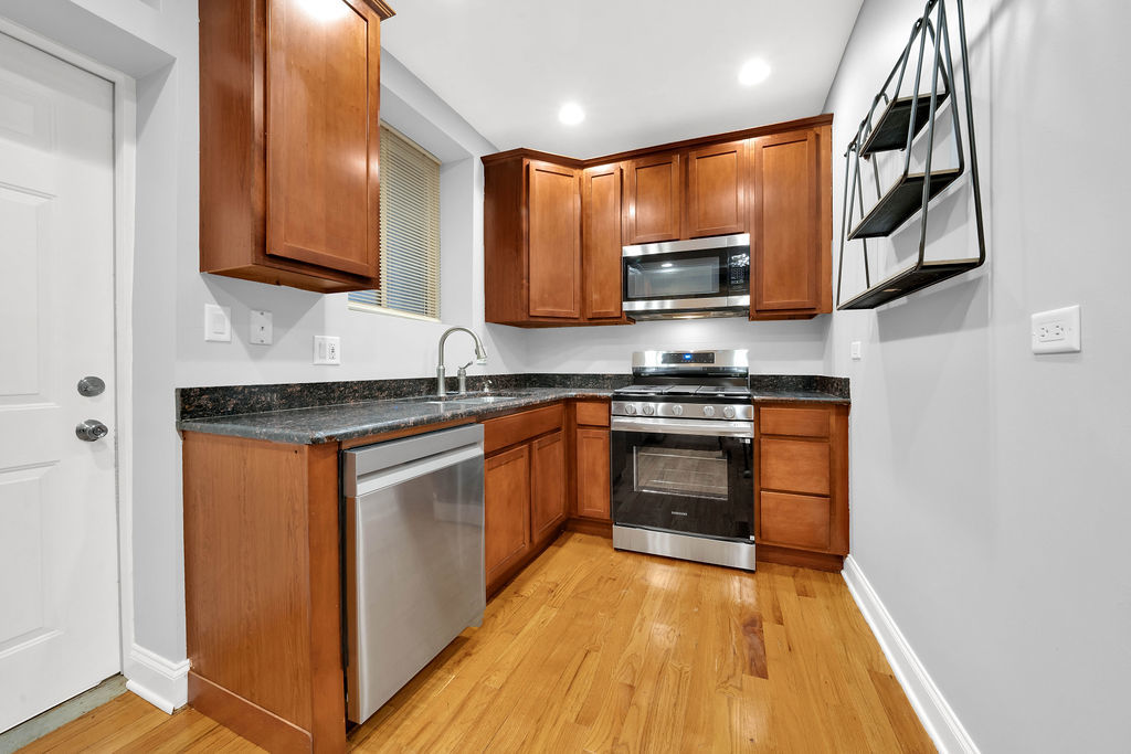 2256 West Arthur Avenue, Unit 2 Chicago, IL 60645 - Photo 6 of 18 a kitchen with stainless steel appliances granite countertop wooden cabinets a stove top oven a sink and dishwasher