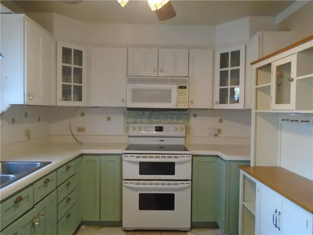 a kitchen with cabinets a sink and stainless steel appliances