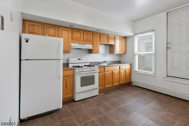 a kitchen with white cabinets and white appliances