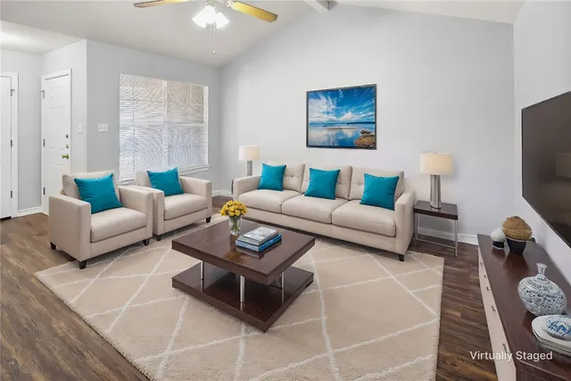 a living room with furniture a rug and a flat screen tv