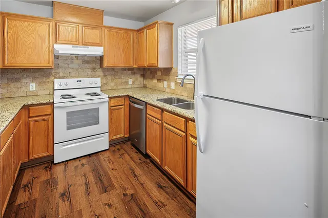 a kitchen with a refrigerator sink and cabinets