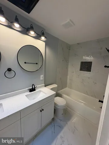 a bathroom with a sink a toilet and bathtub