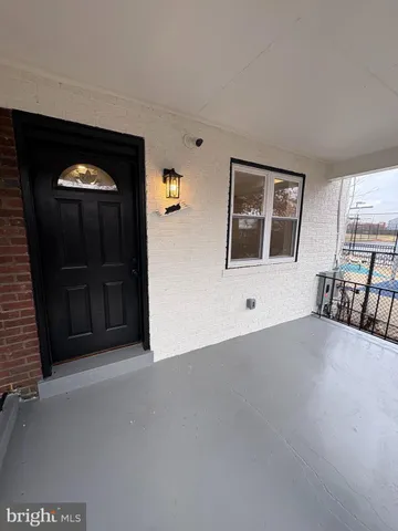 a view of an empty room with furniture and window