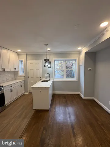 a kitchen with a wooden floor and white appliances