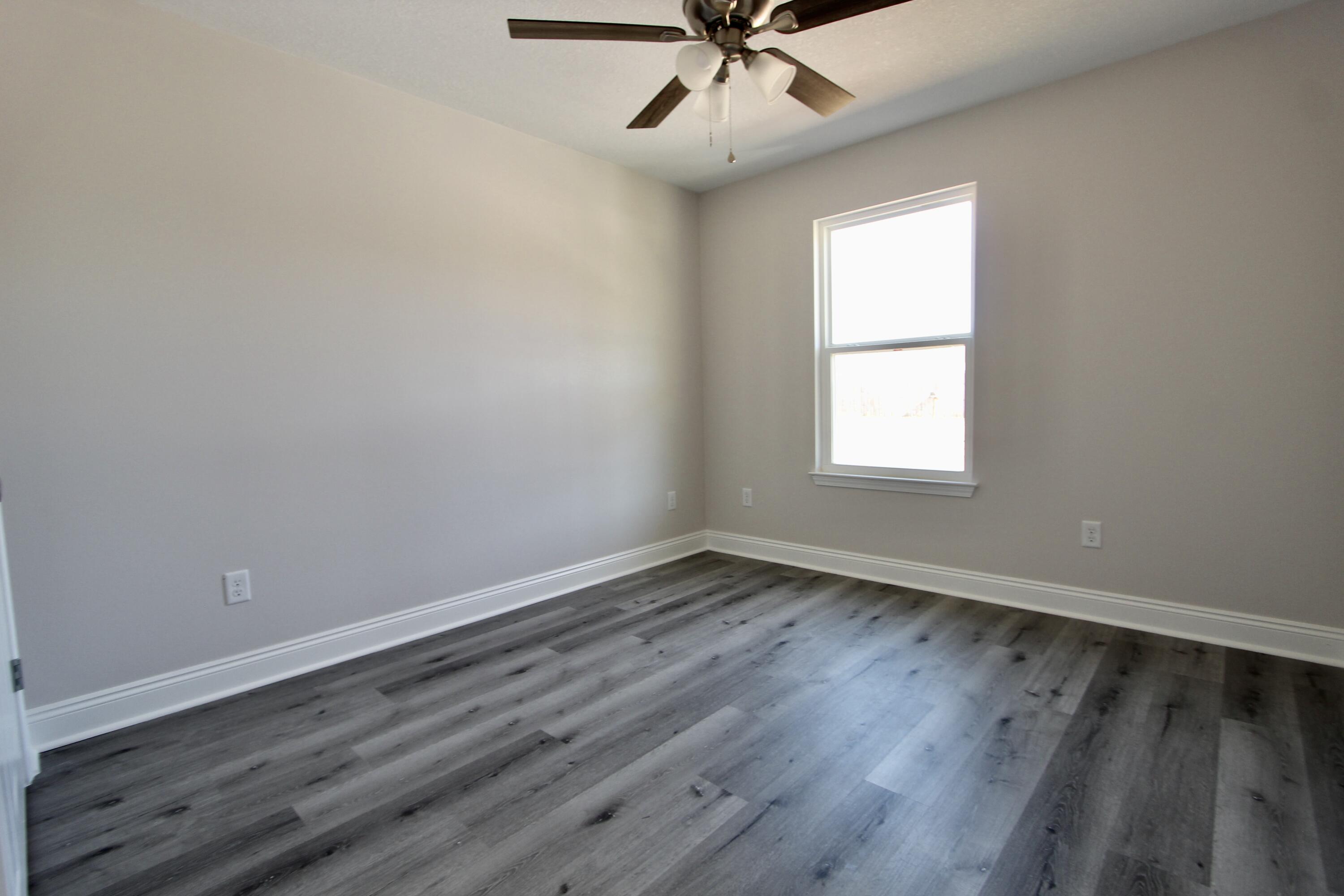 4662 Falcon Way Crestview, FL 32539 - Photo 13 of 20 wooden floor in an empty room with a window