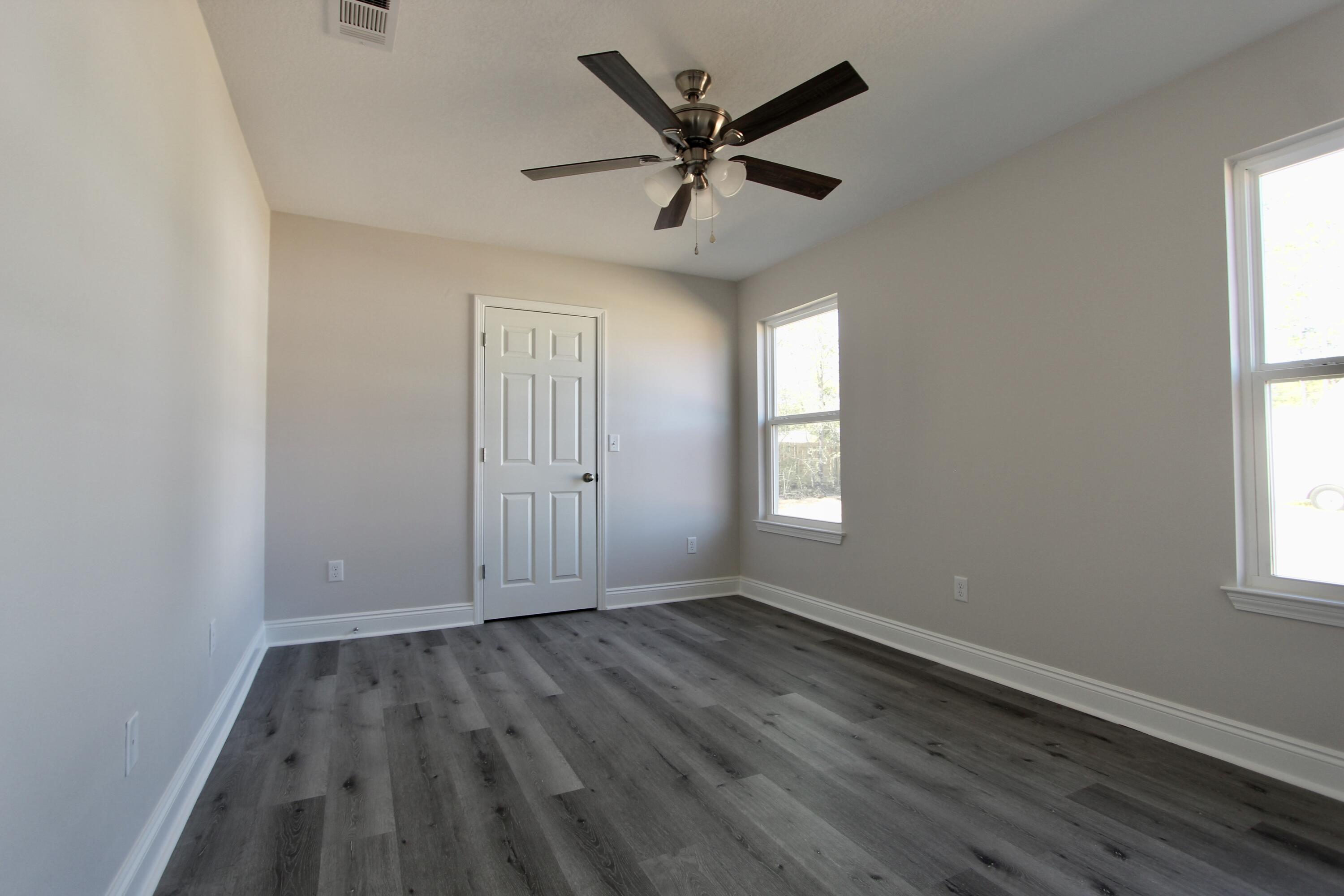 4662 Falcon Way Crestview, FL 32539 - Photo 17 of 20 wooden floor in an empty room with a window