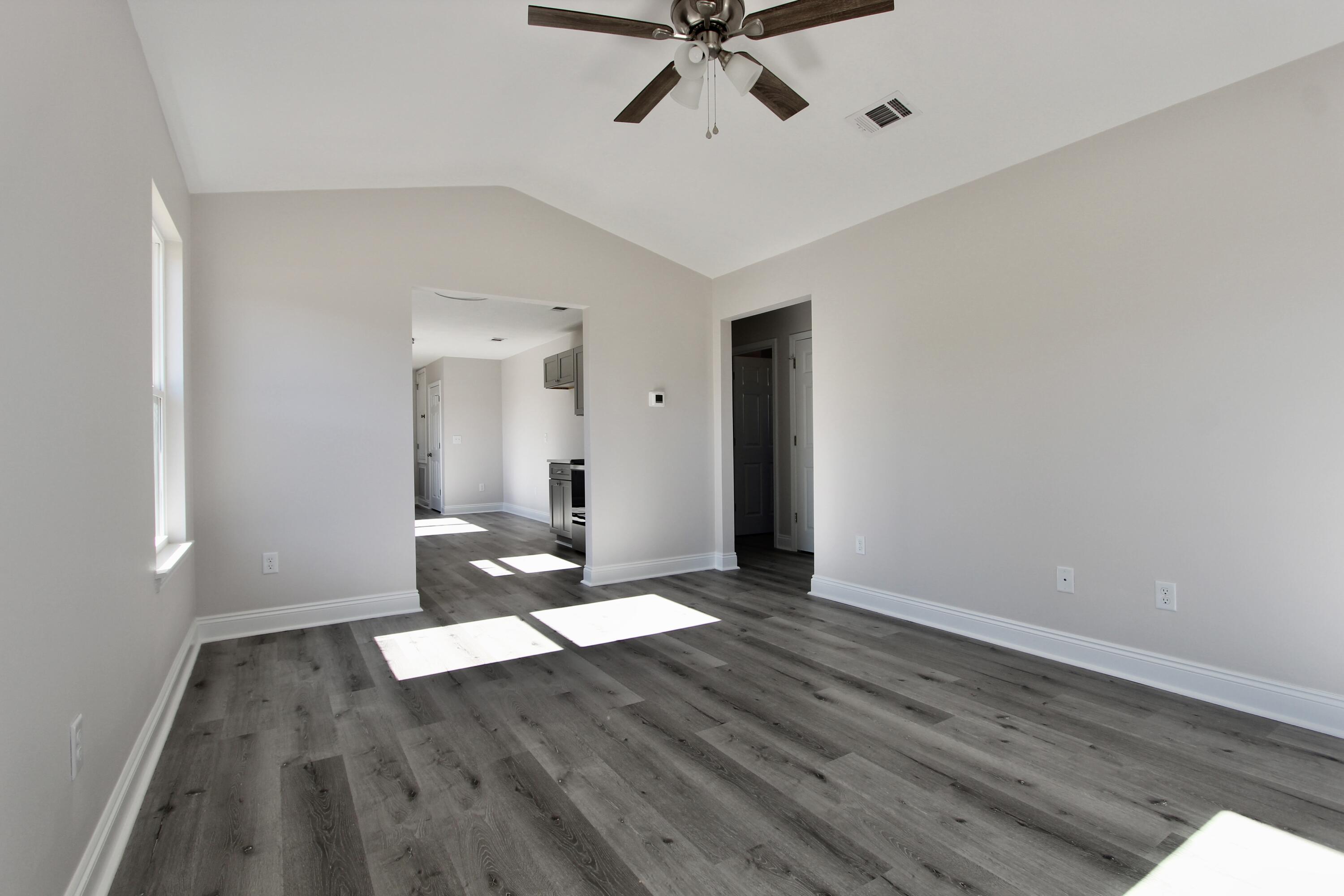 4662 Falcon Way Crestview, FL 32539 - Photo 5 of 20 a view of an empty room with wooden floor and a window