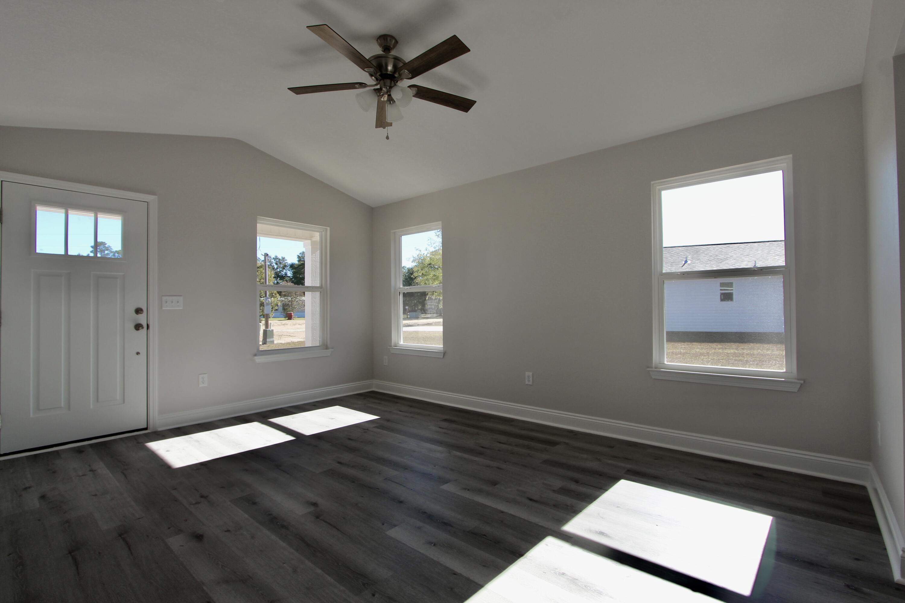 4662 Falcon Way Crestview, FL 32539 - Photo 6 of 20 a view of an empty room with wooden floor and a window