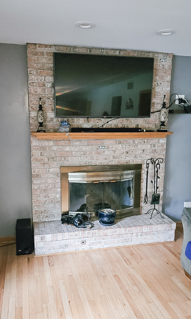 1808 May Drive Johnsburg, IL 60051 - Photo 4 of 32 a living room with a fireplace and a wooden floor