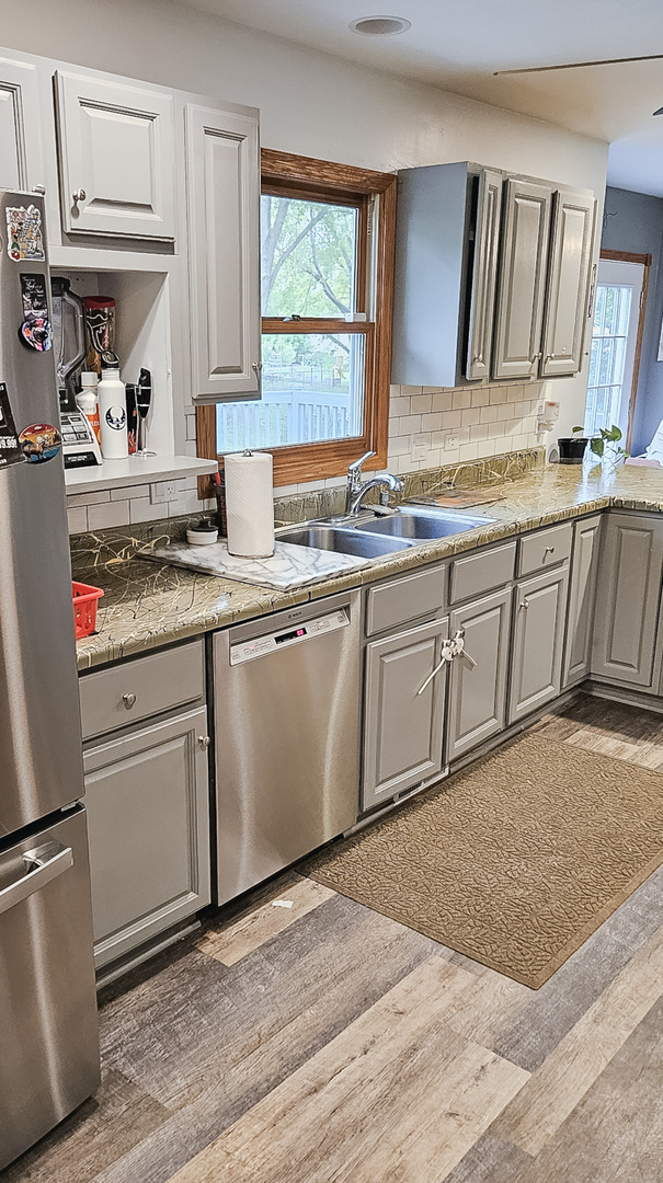 1808 May Drive Johnsburg, IL 60051 - Photo 7 of 32 a kitchen with stainless steel appliances granite countertop a sink stove and cabinets