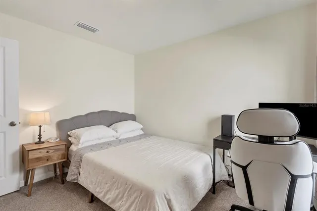 a bedroom with a bed and a lamp on table