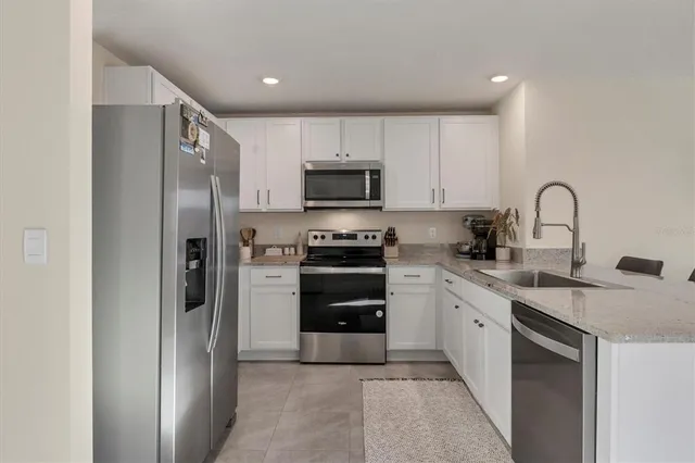 a kitchen with stainless steel appliances a refrigerator sink and stove