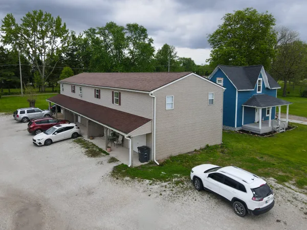a car parked in front of a house with a small yard