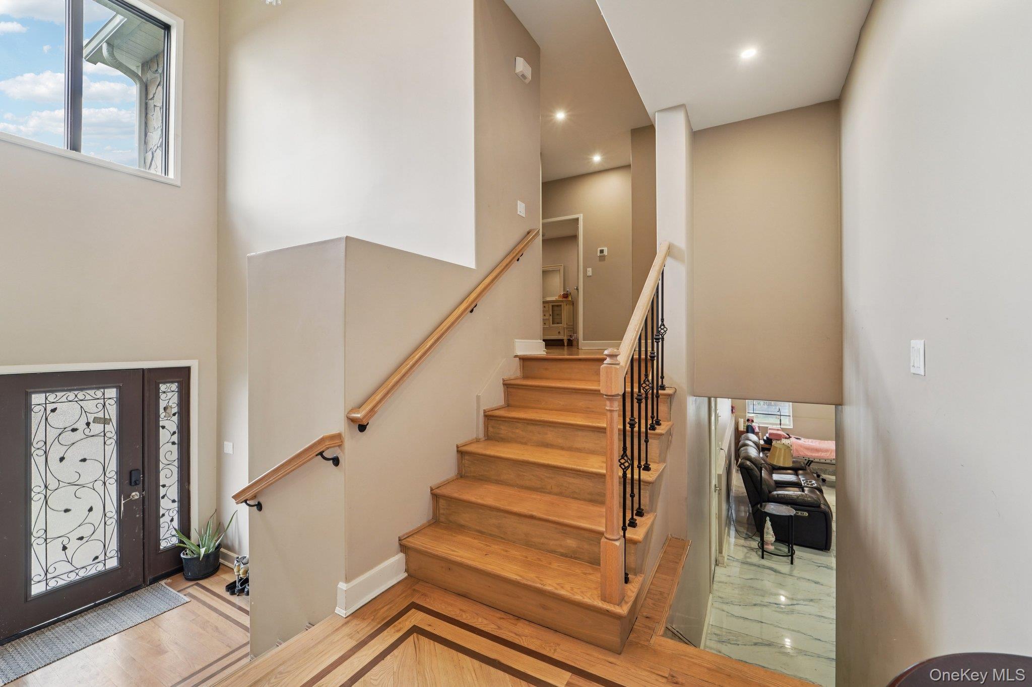 109 Bennett Road Newburgh, NY 12550 - Photo 16 of 41 The property features a grand entryway with a double door entry, a large window, and a staircase with a wooden handrail and wrought iron spindles.