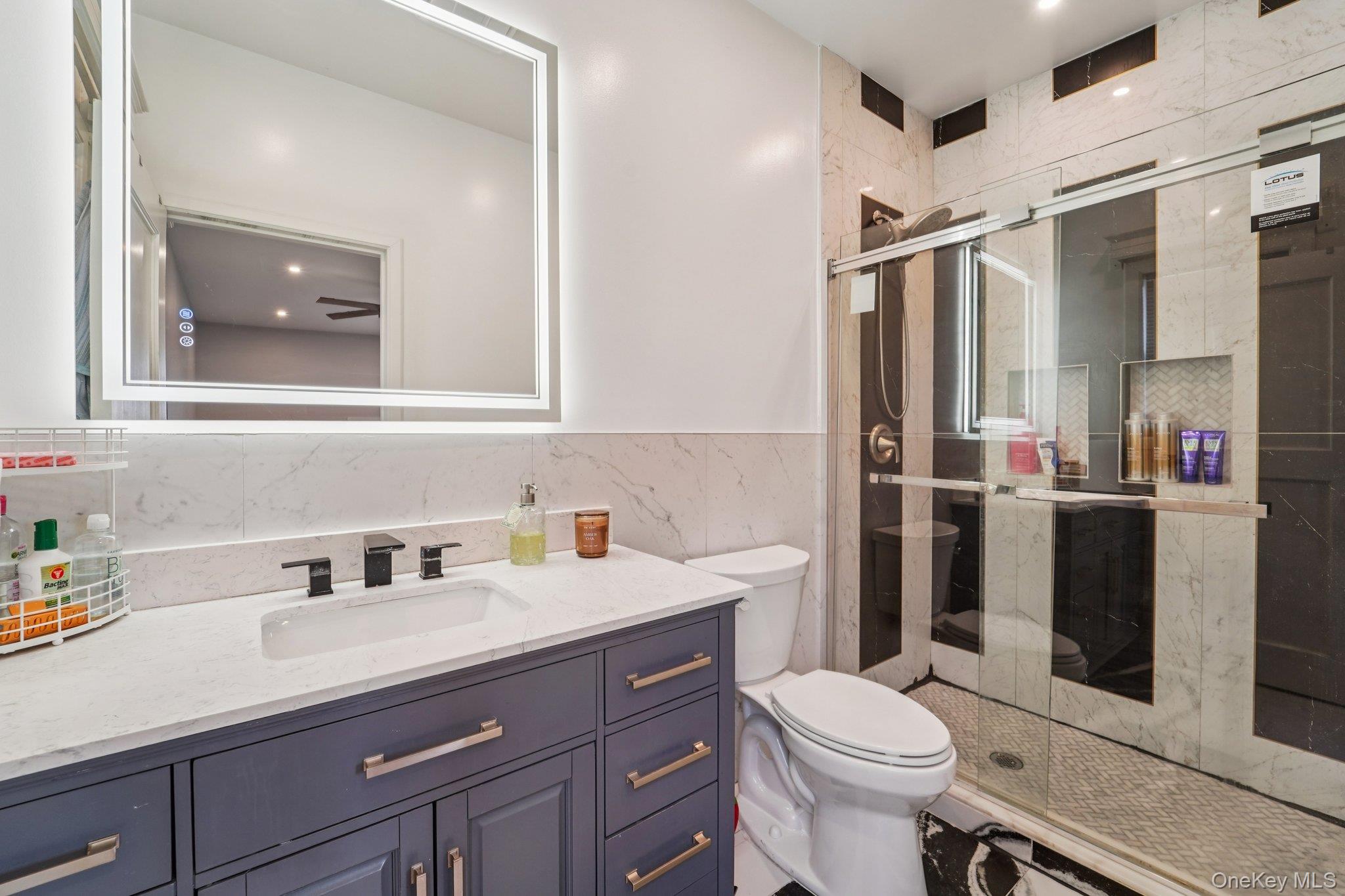 109 Bennett Road Newburgh, NY 12550 - Photo 19 of 41 Bathroom 2: featuring a modern vanity with a white countertop, a rectangular sink, and a large illuminated mirror.