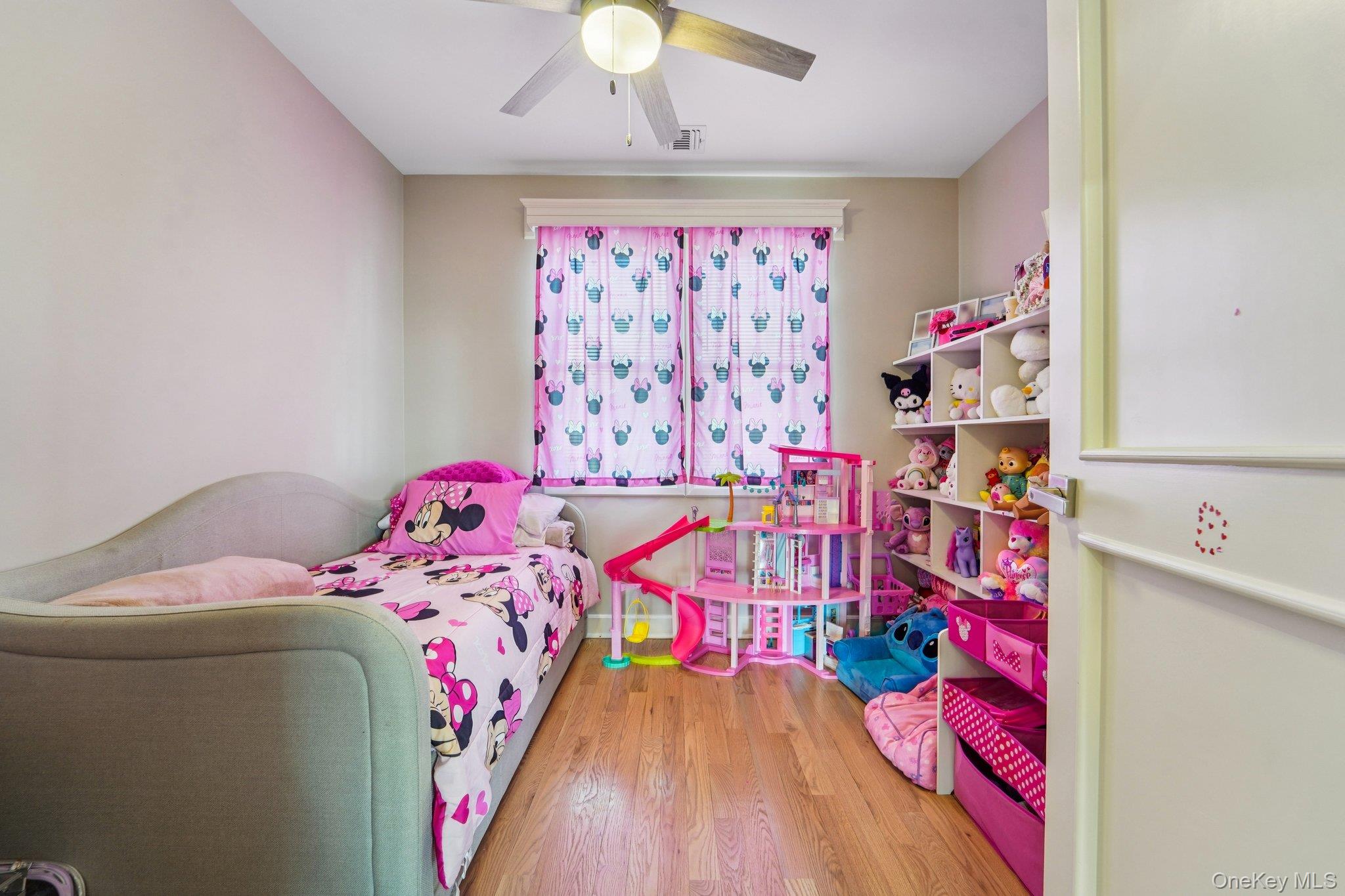 109 Bennett Road Newburgh, NY 12550 - Photo 28 of 41 Bedroom 4: This room features hardwood flooring, a window with patterned curtains, and a ceiling fan with integrated lighting.