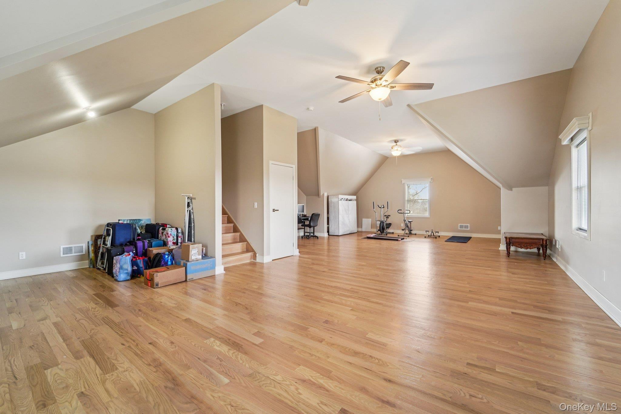 109 Bennett Road Newburgh, NY 12550 - Photo 29 of 41 Expansive room featuring hardwood floors, sloped ceilings, and two ceiling fans for comfort.