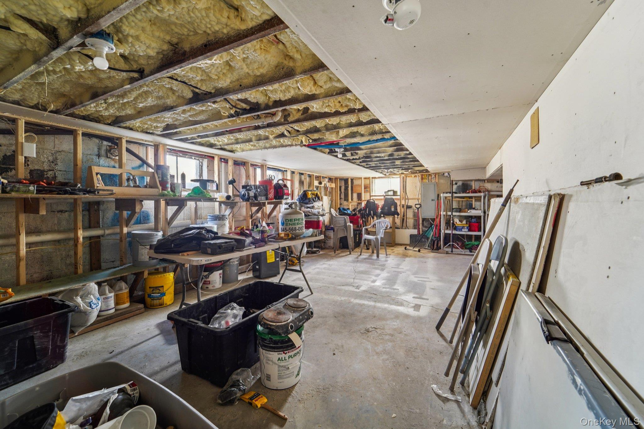 109 Bennett Road Newburgh, NY 12550 - Photo 35 of 41 The property features a utility space with exposed ceiling joists and insulation, concrete flooring, and a partially finished ceiling area.