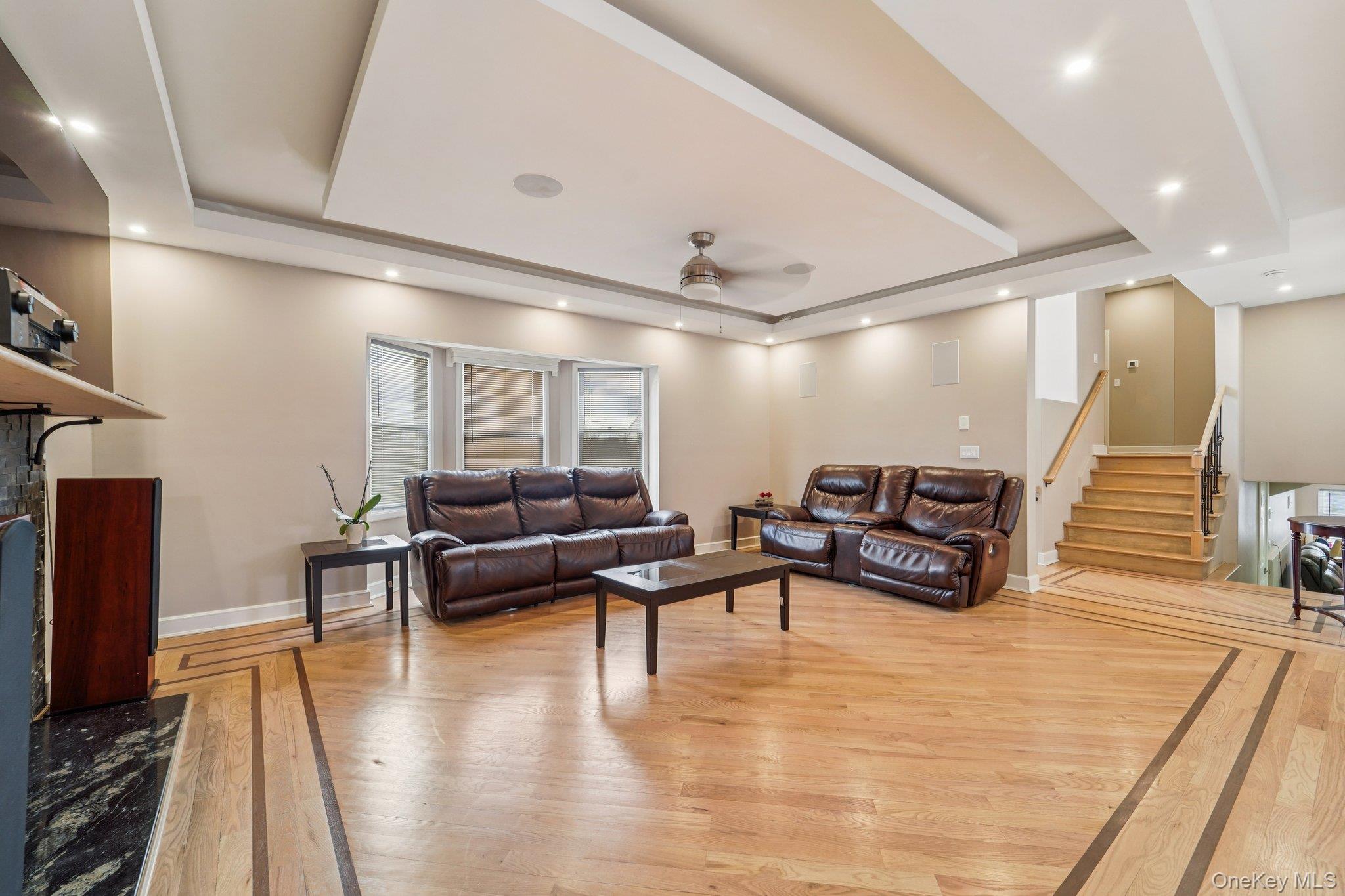 109 Bennett Road Newburgh, NY 12550 - Photo 9 of 41 Spacious living area featuring hardwood flooring with decorative inlay, a bay window, and a tray ceiling with recessed lighting