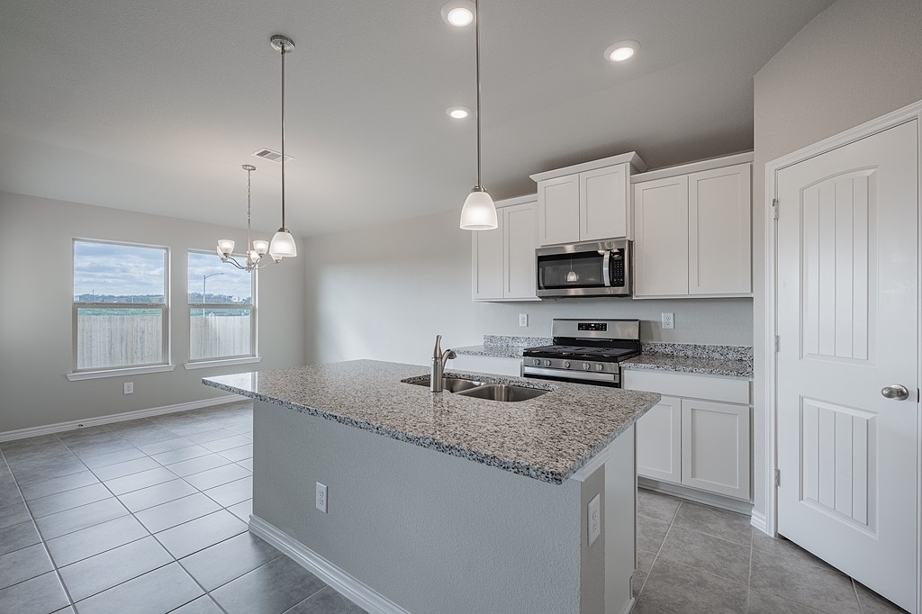 602 Davy Street Brenham, TX 77833 - Photo 4 of 16 a kitchen with granite countertop a sink a counter top space appliances and cabinets