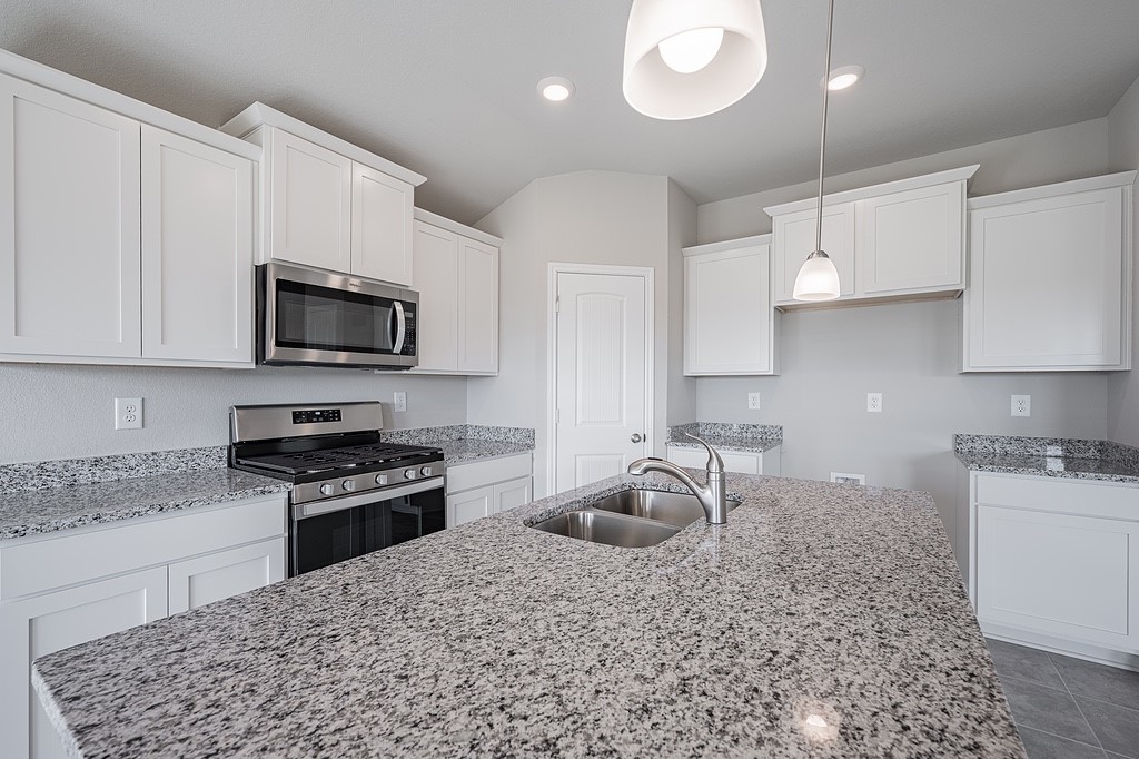 602 Davy Street Brenham, TX 77833 - Photo 5 of 16 a kitchen with granite countertop a sink a stove a oven a counter space and cabinets