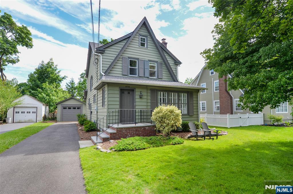 570 Shelton Road Ridgewood, NJ 07450 - Photo 1 of 26 a front view of a house with a yard and garage