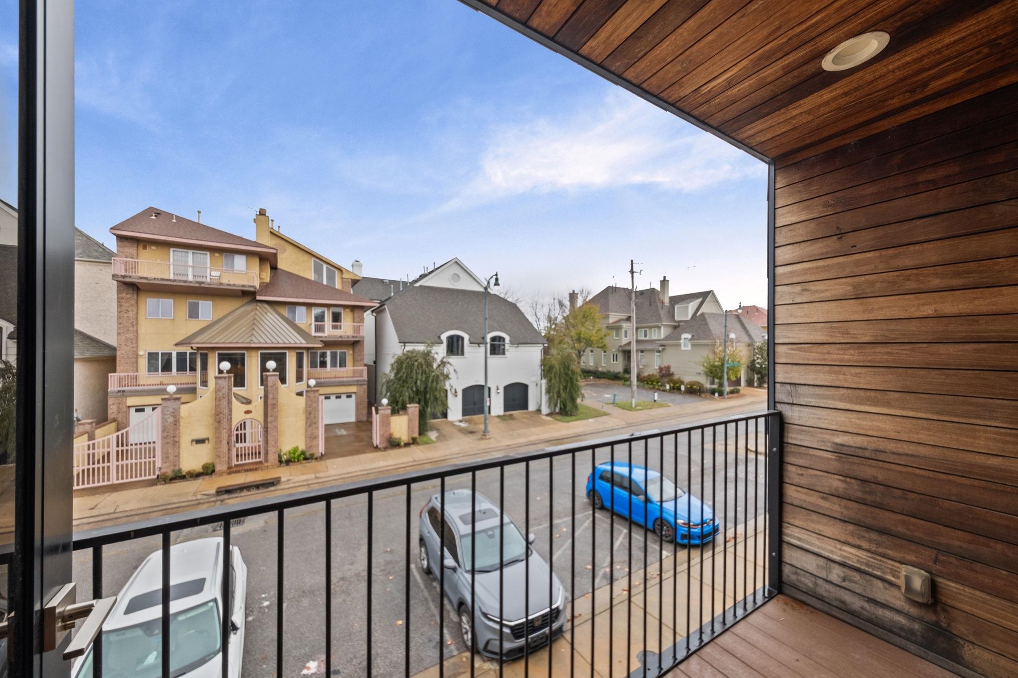 448 Tennessee Street Memphis, TN 38103 - Photo 18 of 39 Balcony featuring wood-finish siding and ceiling, a recessed light fixture, and black metal railings overlooking a residential street