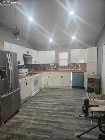 a kitchen with stainless steel appliances granite countertop a refrigerator sink and stove