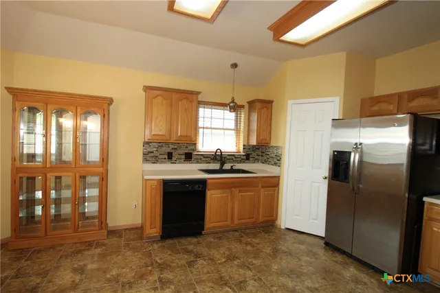 a kitchen with stainless steel appliances granite countertop a refrigerator and a sink