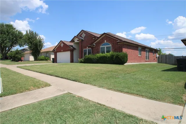 a front view of a house with yard and green space