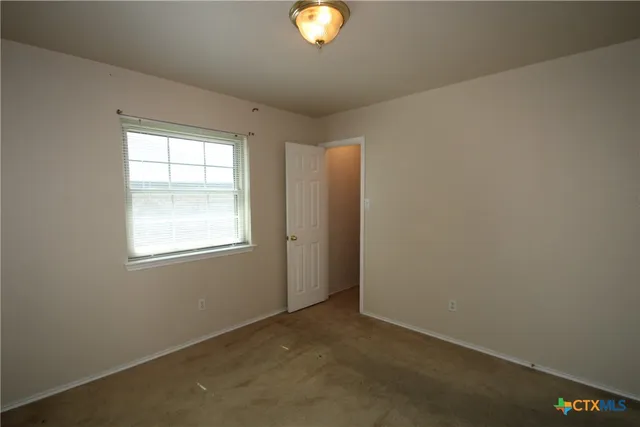 an empty room with window and mirror