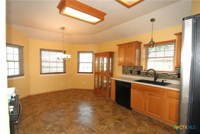 a large kitchen with kitchen island granite countertop a stove a sink dishwasher and a refrigerator