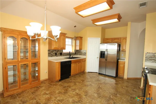 a kitchen with granite countertop a refrigerator and a stove