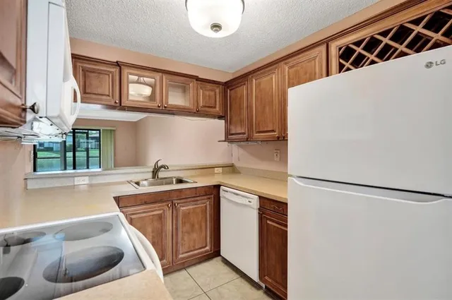 a kitchen with stainless steel appliances granite countertop a sink and a refrigerator