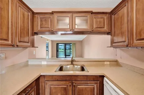 a kitchen with stainless steel appliances granite countertop a sink a stove and cabinets