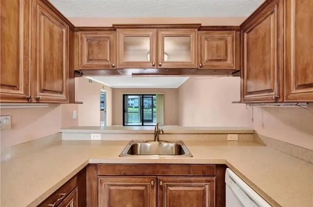 a kitchen with stainless steel appliances granite countertop a sink a stove and cabinets