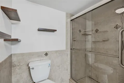 a bathroom with a toilet and a shower