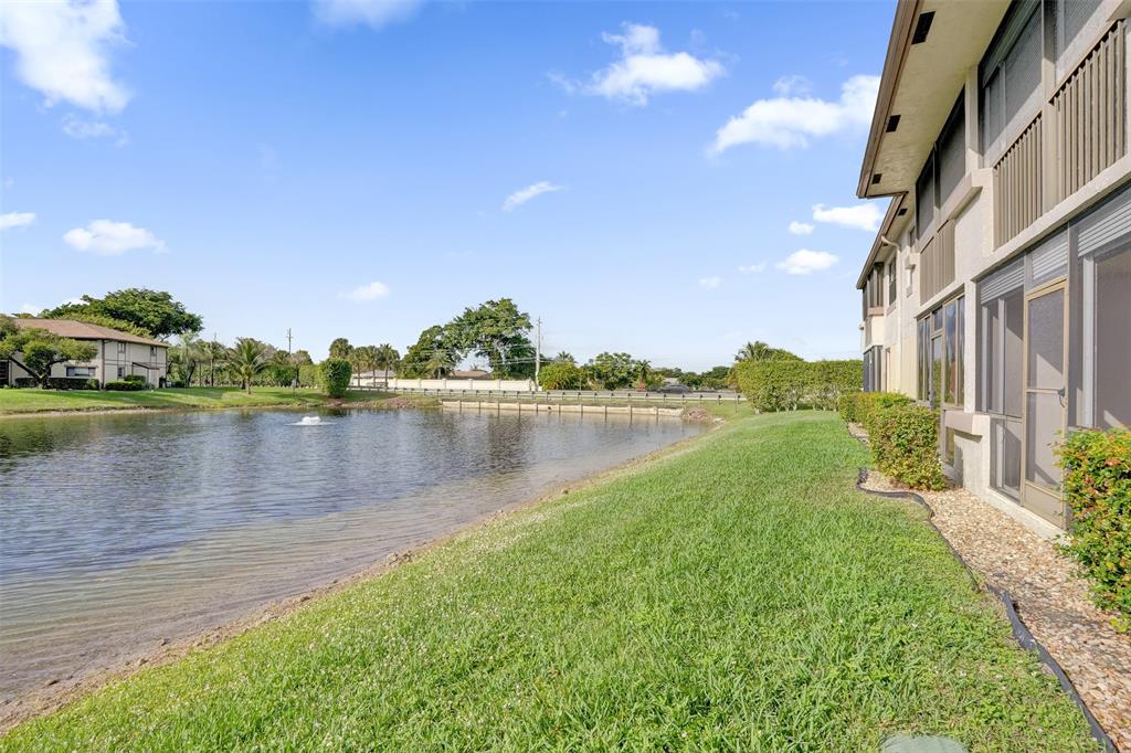 9573 West McNab Road, Unit 109 Tamarac, FL 33321 - Photo 25 of 29 a view of a lake with a building in the background
