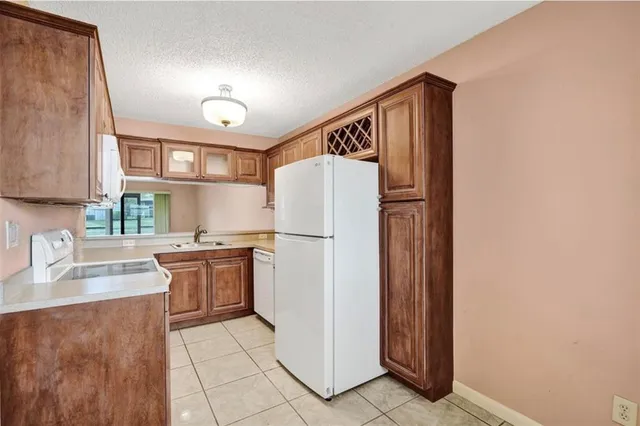 a kitchen with granite countertop cabinets and refrigerator