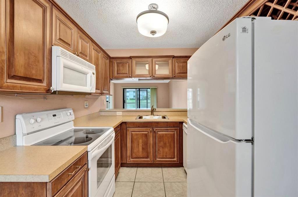 9573 West McNab Road, Unit 109 Tamarac, FL 33321 - Photo 9 of 29 a kitchen that has a sink and a stove in it