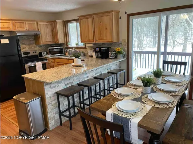 a kitchen with a dining table chairs and white appliances