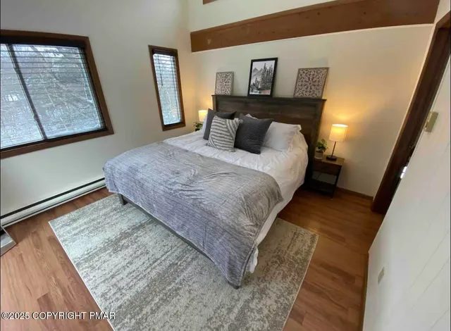 a bedroom with a bed and painting on the wall