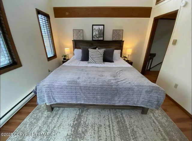 a bedroom with a bed and wooden floor