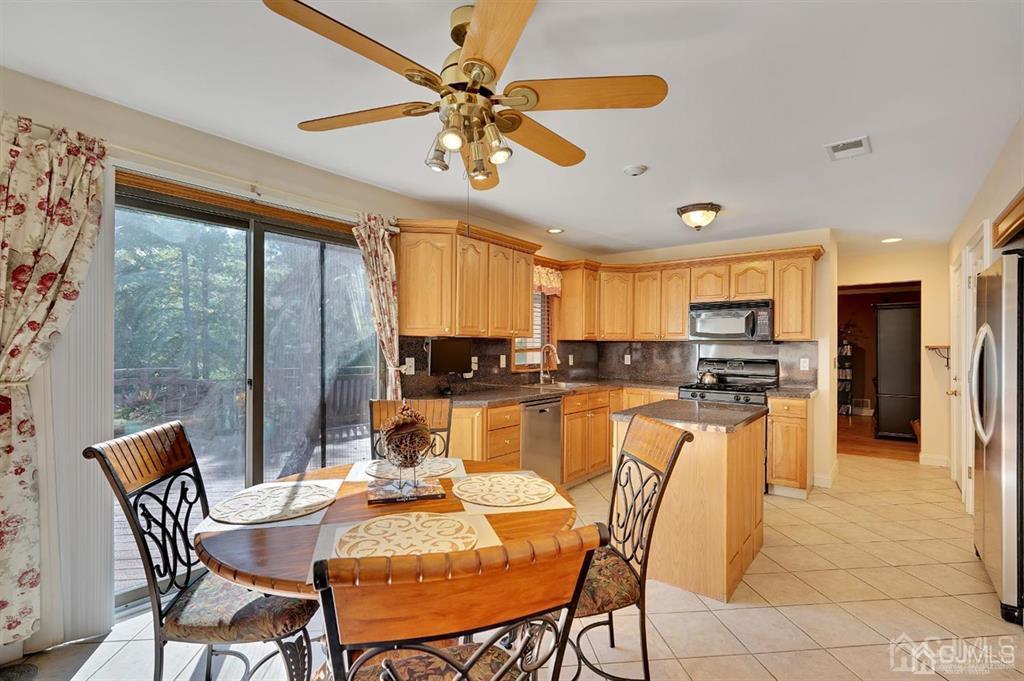 83 Amboy Road Old Bridge, NJ 07747 - Photo 9 of 40 a dining room with a table chairs and a kitchen view
